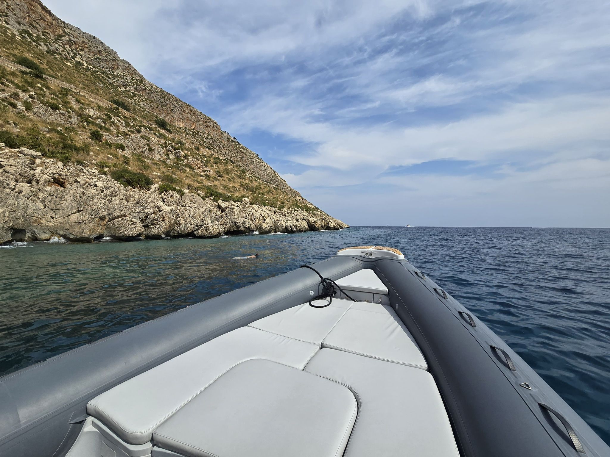 Vista dalla prua di un gommone su una costa rocciosa