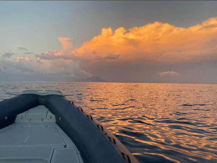 Tramonto in mare visto dalla prua del gommone